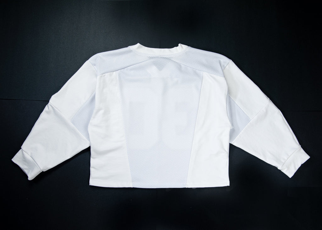 A white long-sleeve athletic jersey shown from the back, laid flat on a dark black background. The back features a large, tonal number '16' printed across the center.