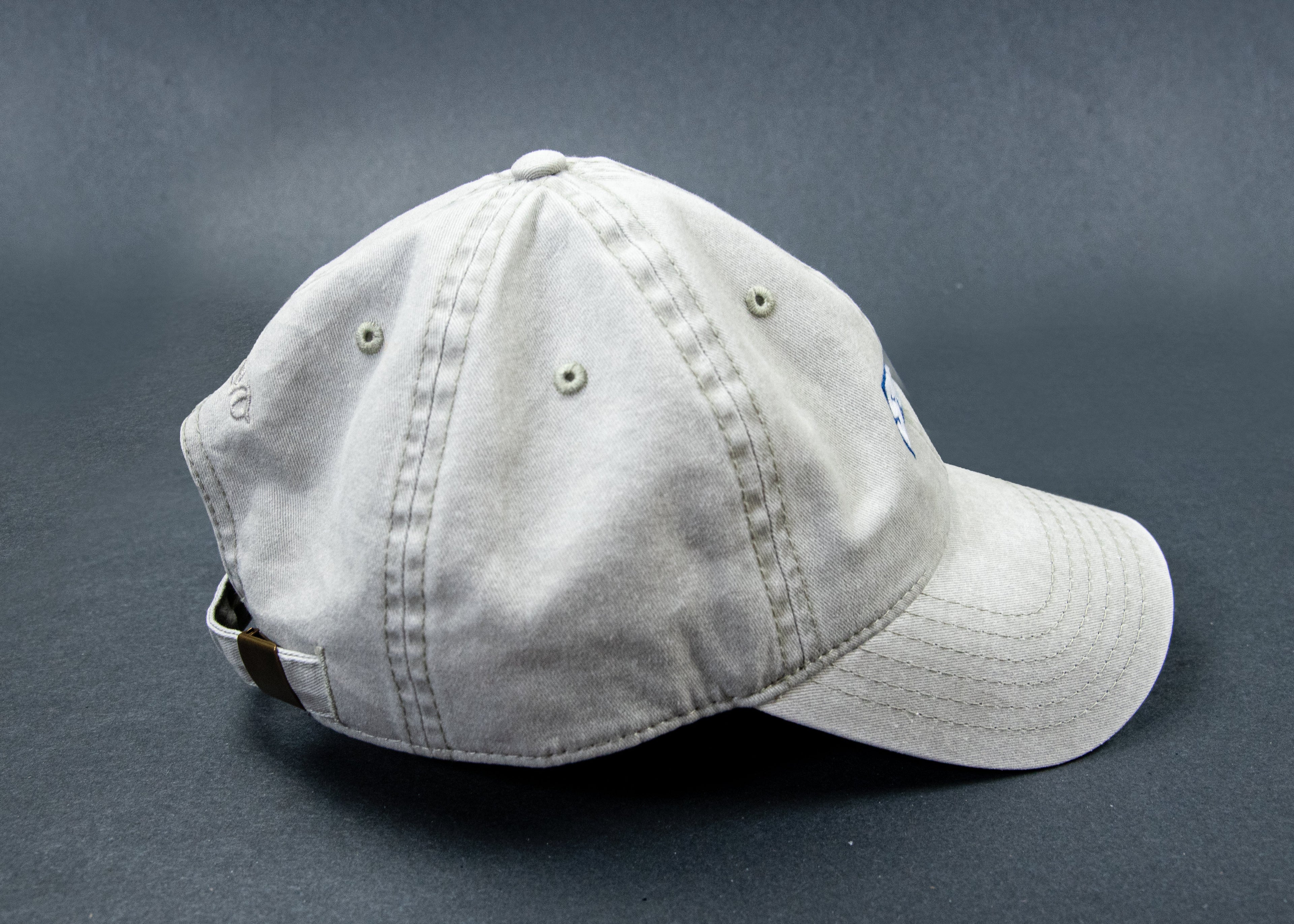 A light gray washed cotton baseball cap with a curved brim, shown from a side angle on a dark gray background.
